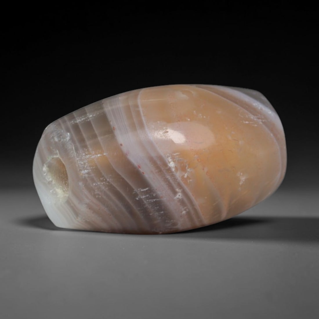 Ancient Sogdian Culture Banded Agate Barrel Bead (500 BCE-800 CE), 24AD: This antique banded agate barrel bead originates from the Sogdian Culture, key Silk Road merchant artisans who operated agate bead workshops facilitating trade between China, Persia, and South Asian c