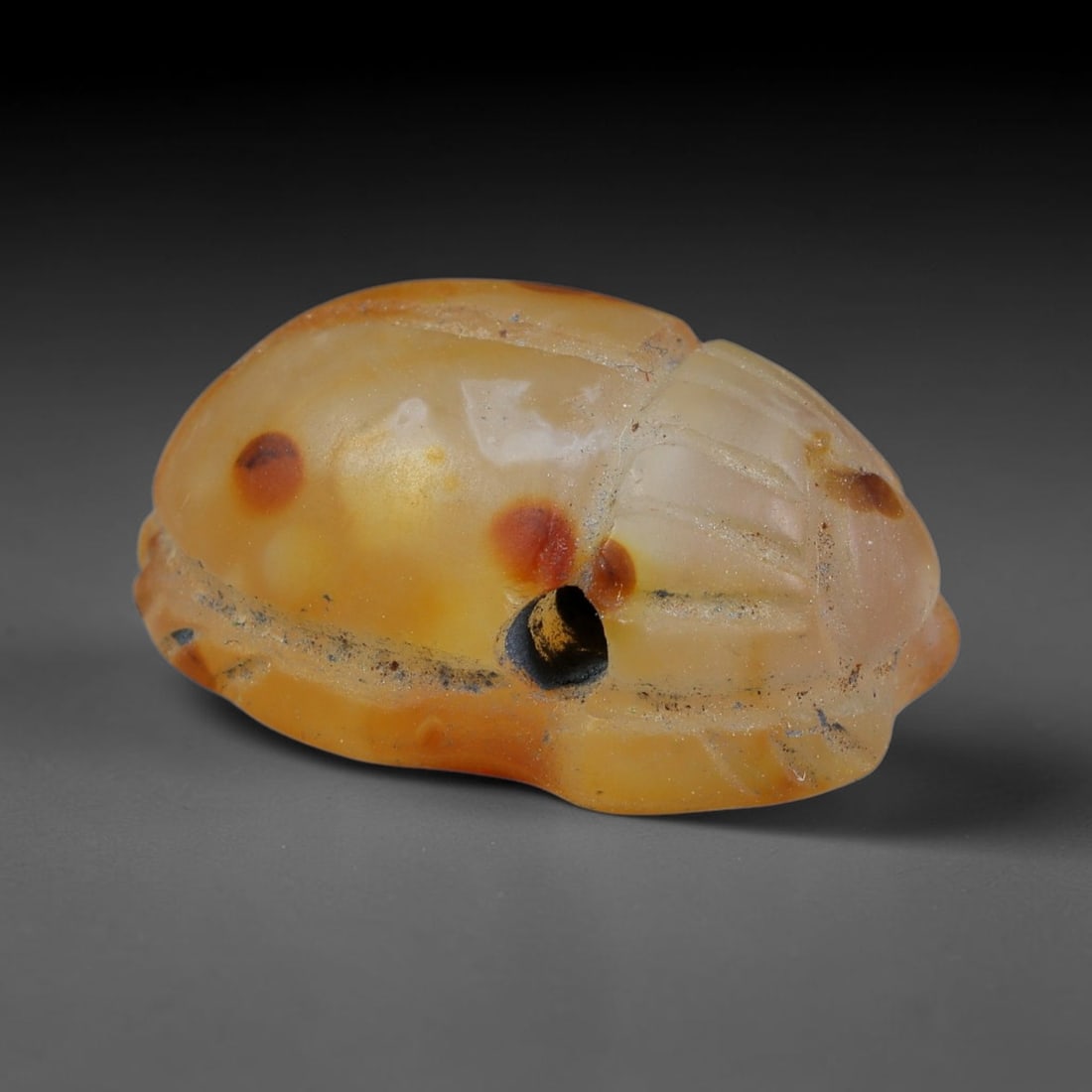 Ancient Pharaonic Egyptian Agate Scarab Amulet Bead (3100 BCE-30 CE), 25EC: This antique scarab amulet bead is carved from natural agate, originating from Pharaonic Egyptian culture. Scarabs were sacred protective talismans closely linked to rebirth and eternal life within an