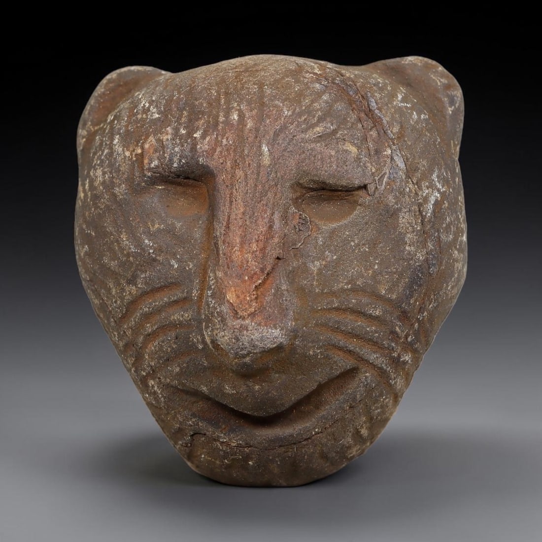 Ancient Medieval Near Eastern Stone Zoomorphic Head (600-1100 CE), 73EJ: This antique stone zoomorphic head originates from medieval Near Eastern cultural tradition, created for ceremonial and talismanic function. The dense stone bears heavy agerelated patina, surface eros