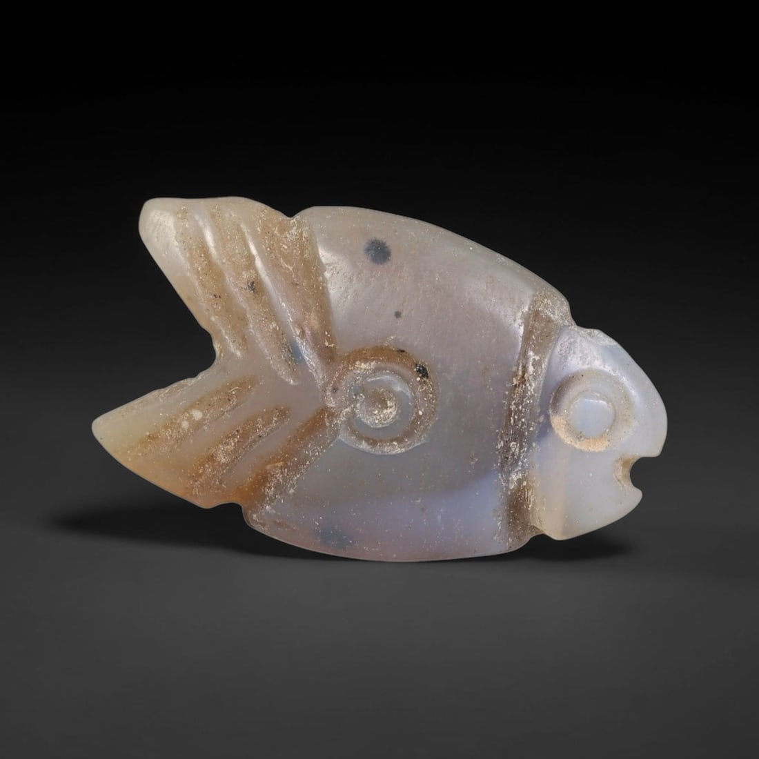Ancient Coptic Christian Egyptian Culture Chalcedony Fish Amulet Bead (300-1000 CE), 31EC: This antique fish-shaped amulet bead carved from pale chalcedony originates from Coptic Christian Egyptian culture, where the fish served as a core sacred symbol of faith and protection within early C