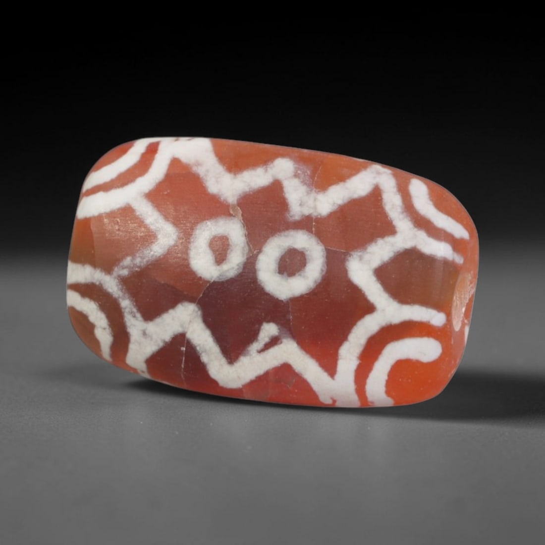Antique Sino-Himalayan Region Etched Carnelian Bead, 84EG: Antique etched carnelian bead originating from the Sino-Himalayan region. Exhibits characteristic surface patina and traditional etched white decoration. Dimensions: 14x8mm, fully pierced for suspensi