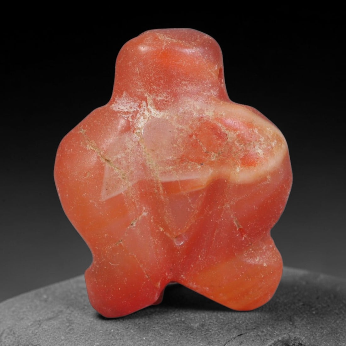 Ancient Coptic Egyptian Carnelian Agate Human Figure Zoomorphic Amulet, 77AA: Genuine ancient Coptic Egyptian devotional talisman hand-carved from natural banded carnelian agate, measuring 2cm x 1.8cm. The solid miniature stone carving takes the form of a stylized plump human b