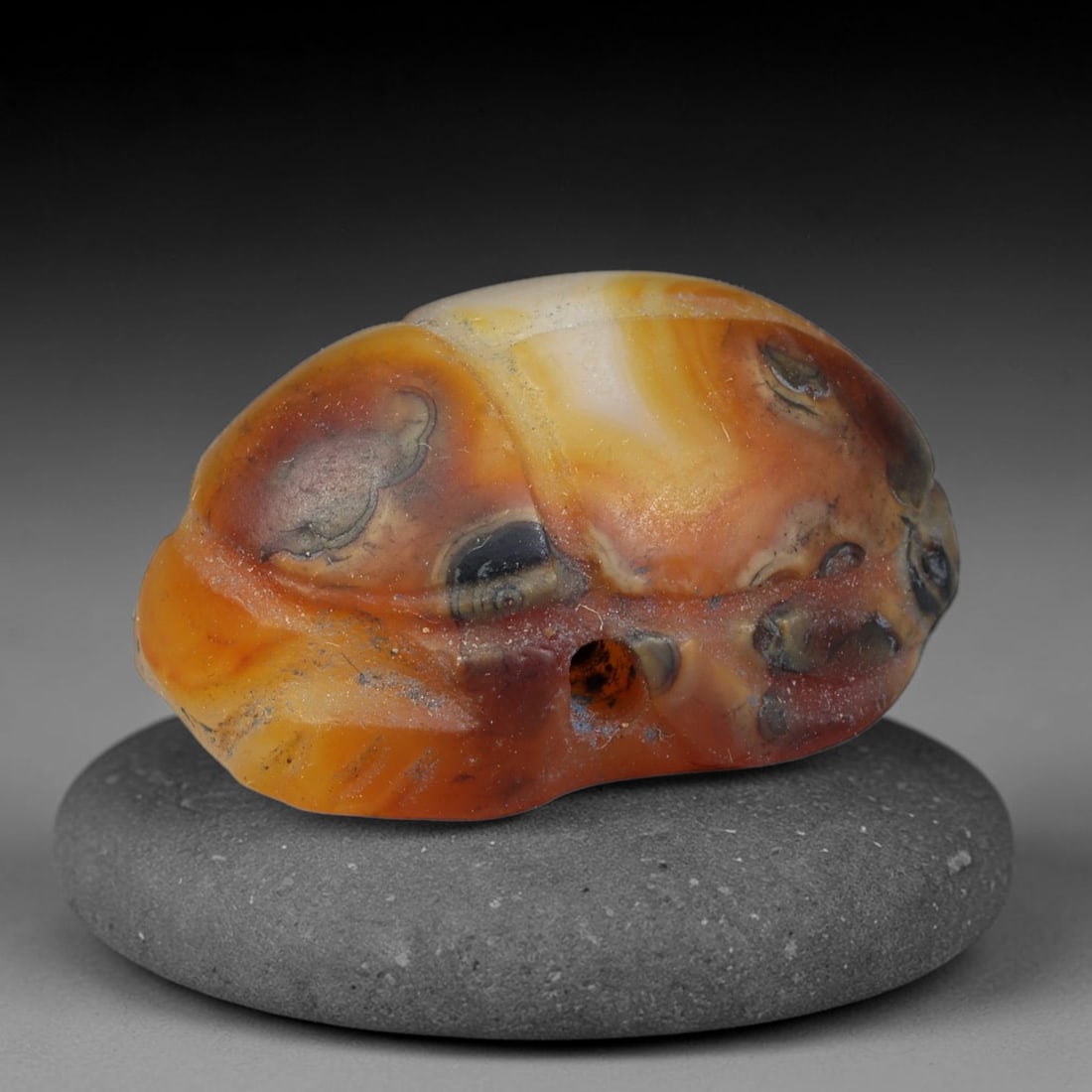Ancient Pharaonic Egyptian Agate Scarab Amulet Bead (3100 BCE-30 CE), 44EC: This antique scarab amulet bead is carved from natural agate, originating from Pharaonic Egyptian culture. Scarabs were sacred protective talismans closely linked to rebirth and eternal life within an