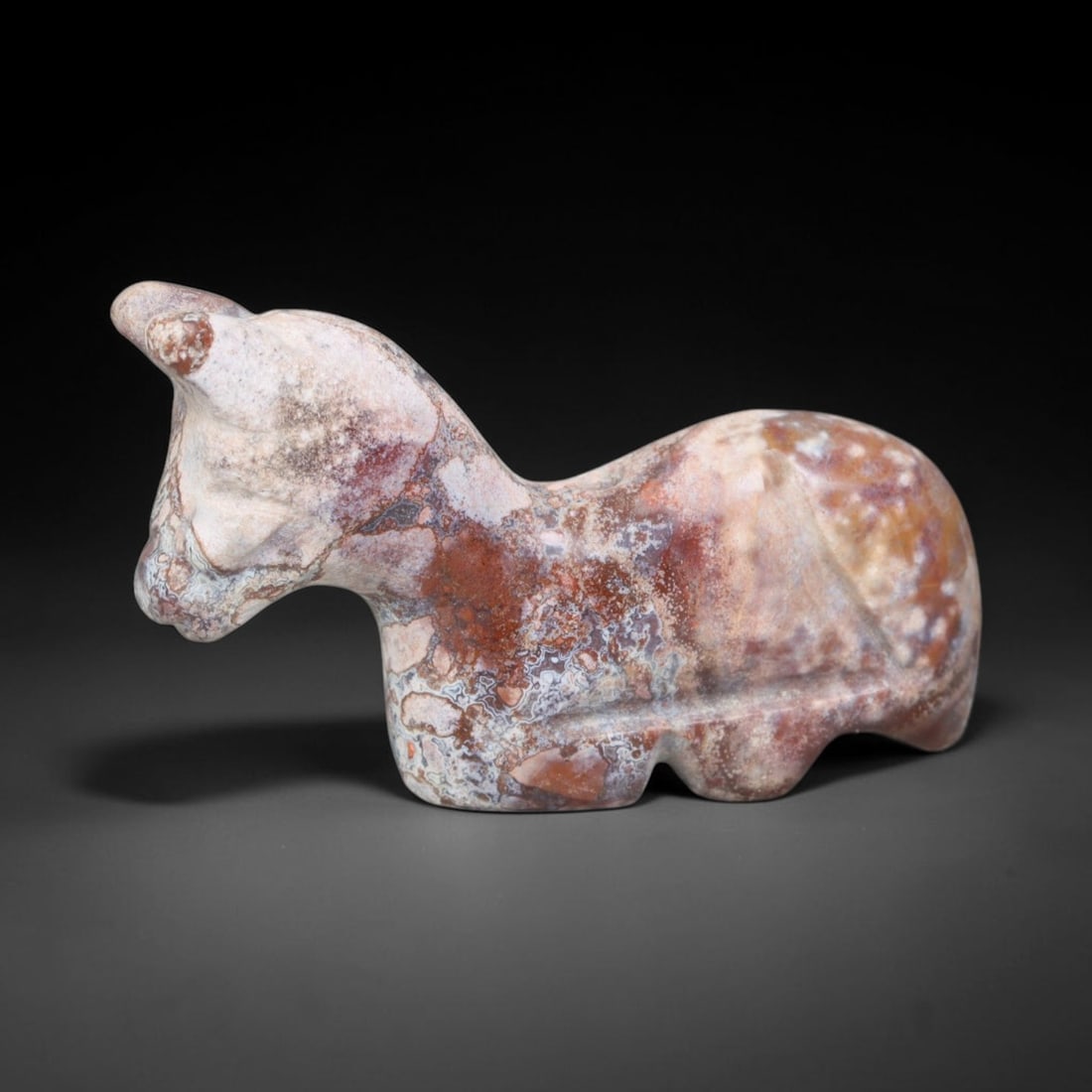 Ancient Bactrian Mottled Agate Recumbent Horse Amulet (c.200-200 BCE), 68EQ: Hand-carved from naturally patterned multi-toned agate originating from ancient Bactria in Central Asia. Rendered as a compact recumbent horse effigy crafted for suspension as a personal talisman, wit