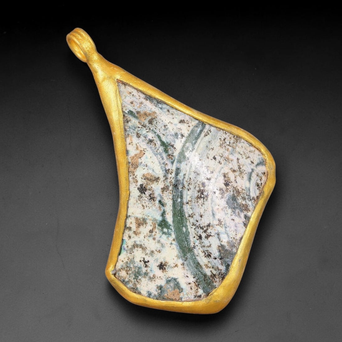 Ancient Roman Glass Slag in Modern Gilt-Edge Pendant, 66FY: This contemporary pendant is crafted from ancient Roman glass slag, featuring a fragmented, iridescent glass surface with weathered patina. The irregular form is bordered by a subtle gilt frame, added