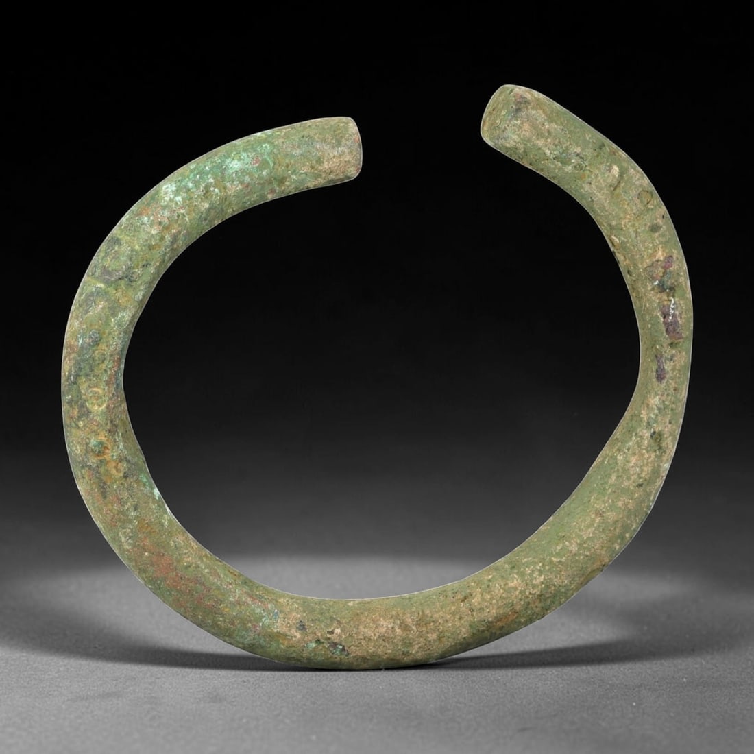 Ancient Bronze Bracelet - Roman Open Cuff Bangle, 38BN: An open-form bracelet crafted from thick cast bronze, with a robust rounded cross-section and squared terminals. The utilitarian form is characteristic of Roman provincial jewelry, designed for durabi