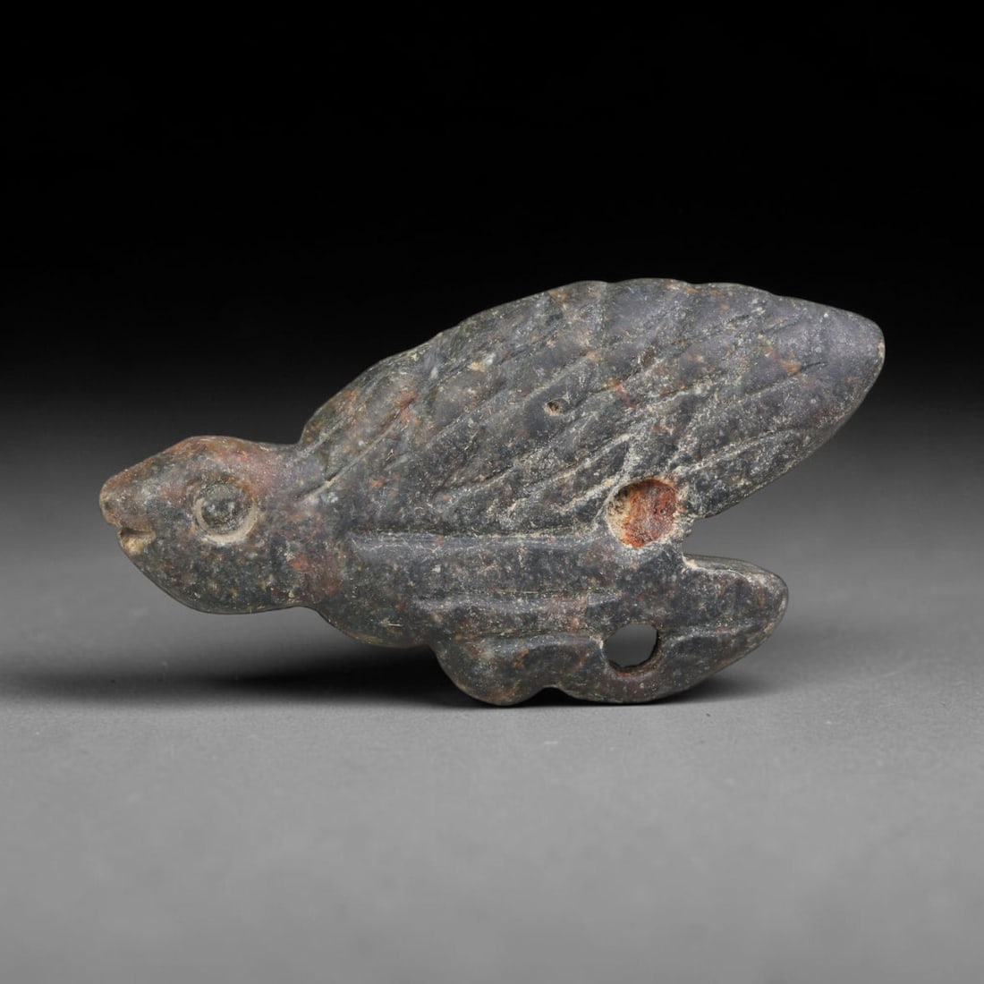 Ancient Sasanian Persian Dark Stone Zoomorphic Amulet (224-651 CE), 86ED: This antique dark stone zoomorphic amulet originates from Ancient Sasanian Persian civilisation. The artifact is shaped in zoomorphic form with finely incised surface detailing and multiple drilled pe