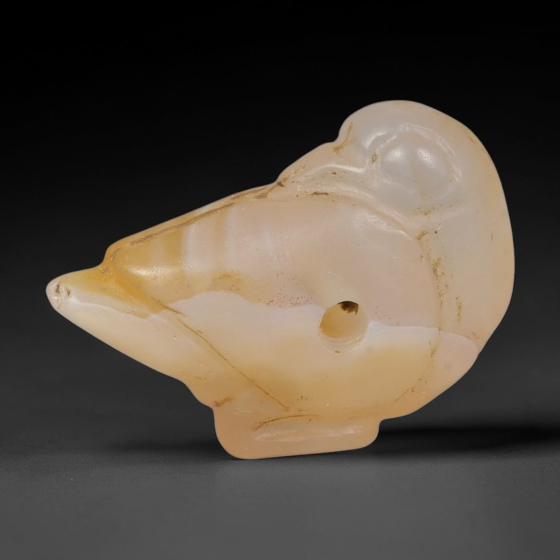 Ancient Near Eastern Natural Banded Agate Bird Amulet (800-300 BCE), 33AB: Miniature hand-carved translucent banded agate resting bird talisman, shaped with smooth rounded head, tapered beak and small integrated foot base. Natural warm amber banding flows through the pale st