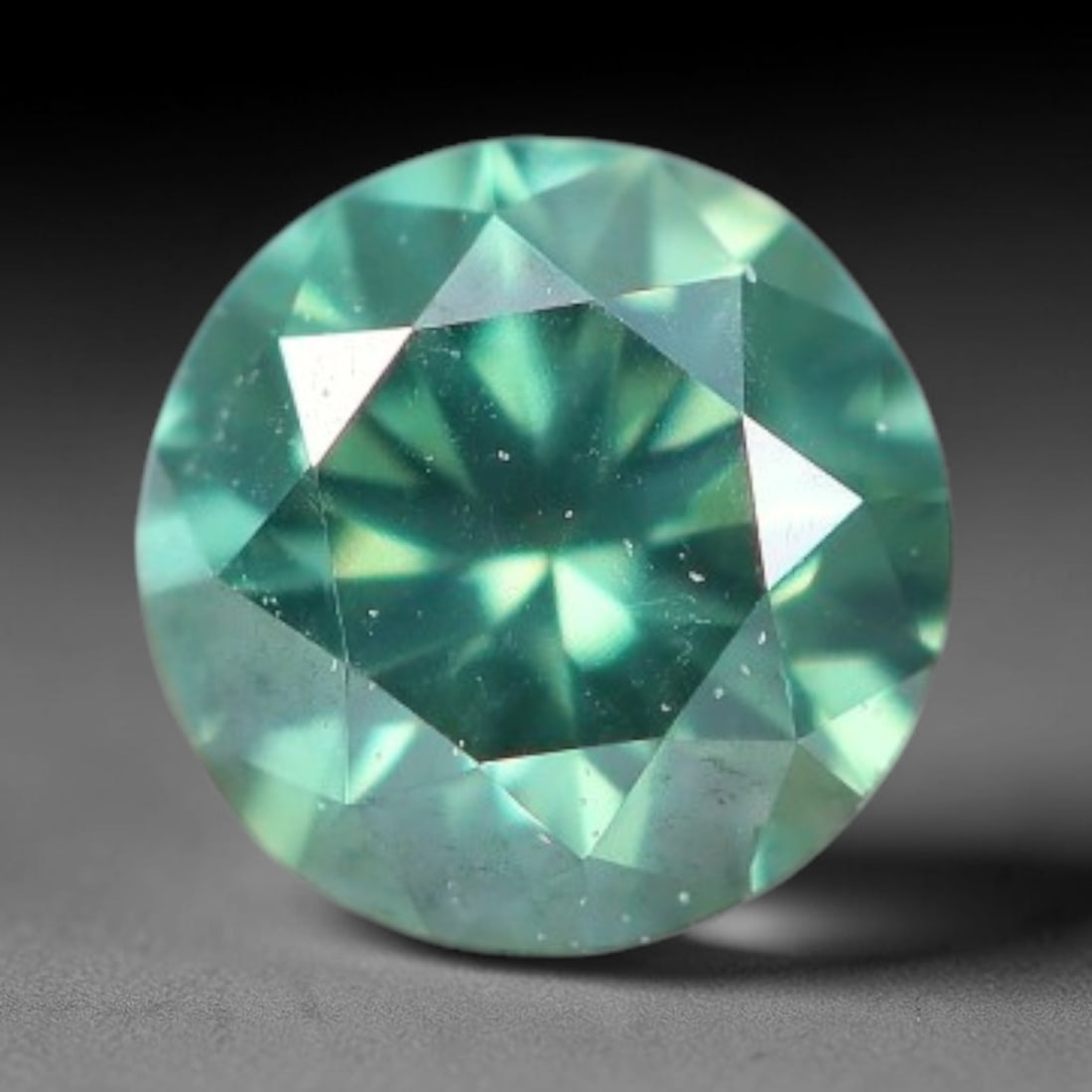 0.11ct Round Natural Fancy Green Diamond Loose Gemstone, 3BH: This polished natural round fancy diamond displays soft mint-green colouration, with fine microscopic native mineral specks scattered within its crystal interior, measured at calibrated dimensions of 