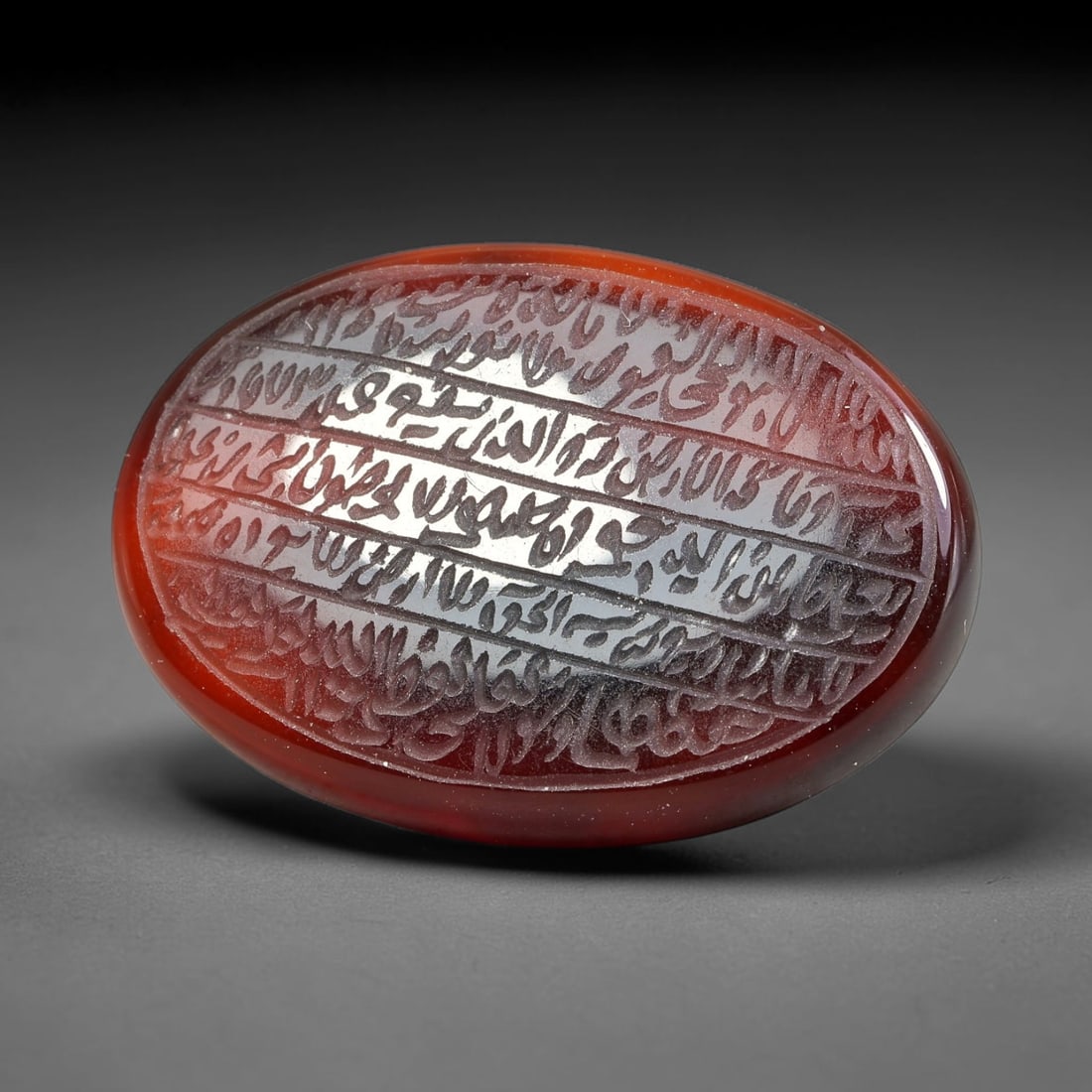 Ancient Medieval Mughal Islamic Carnelian Agate Calligraphic Script Talisman 1526-1857 CE, 24ES: Polished rich-toned carnelian agate cabochon, finely engraved with divided panels of Islamic calligraphic intaglio inscriptions. Deep crisp engraving features segmenting incised lines organizing the s
