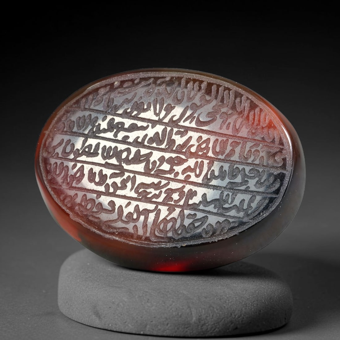 Ancient Medieval Mughal Islamic Carnelian Agate Calligraphic Script Talisman 1526-1857 CE, 50ES: Polished rich-toned carnelian agate cabochon, finely engraved with divided panels of Islamic calligraphic intaglio inscriptions. Deep crisp engraving features segmenting incised lines organizing the s