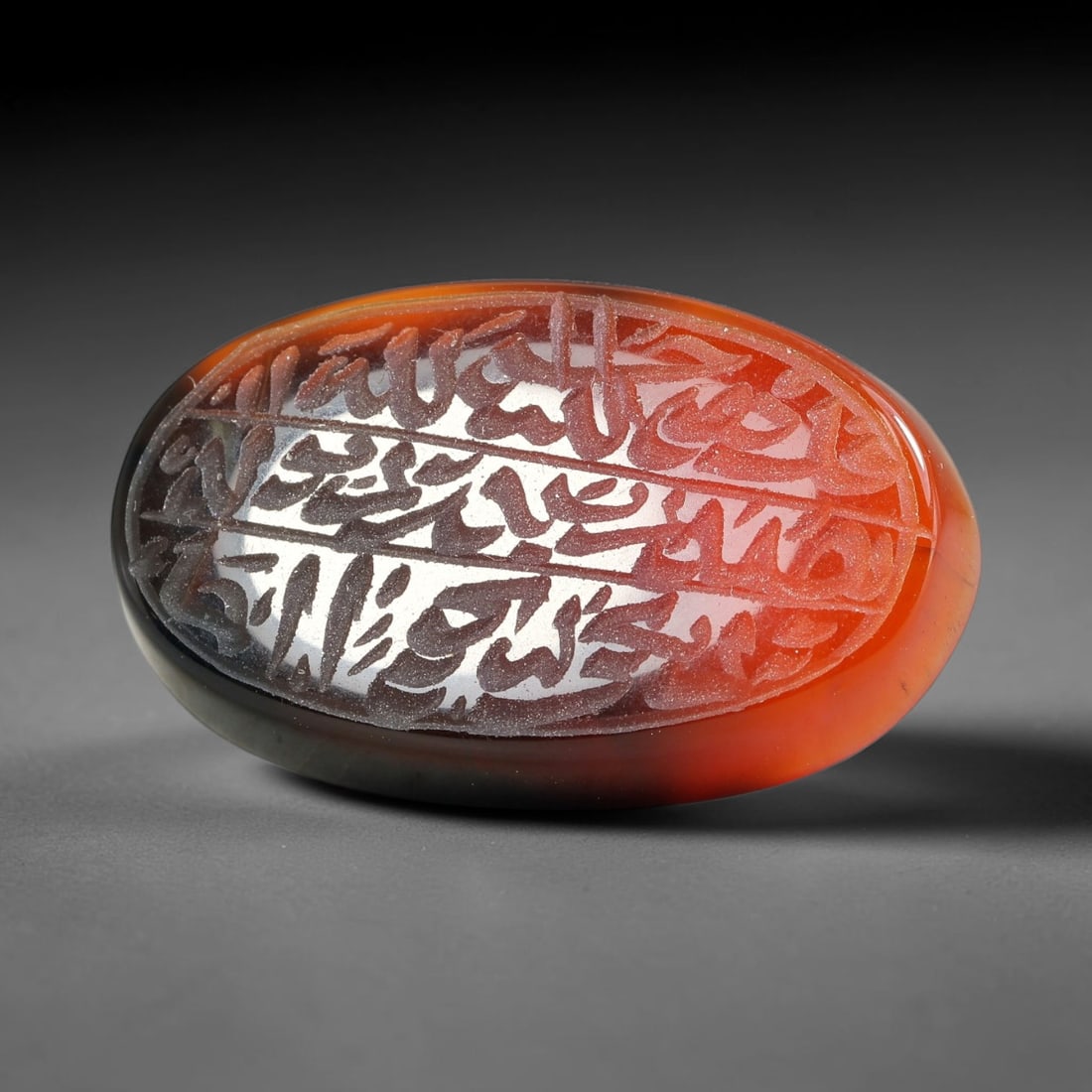 Ancient Medieval Mughal Islamic Carnelian Agate Calligraphic Script Talisman 1526-1857 CE, 36ES: Polished rich-toned carnelian agate cabochon, finely engraved with divided panels of Islamic calligraphic intaglio inscriptions. Deep crisp engraving features segmenting incised lines organizing the s