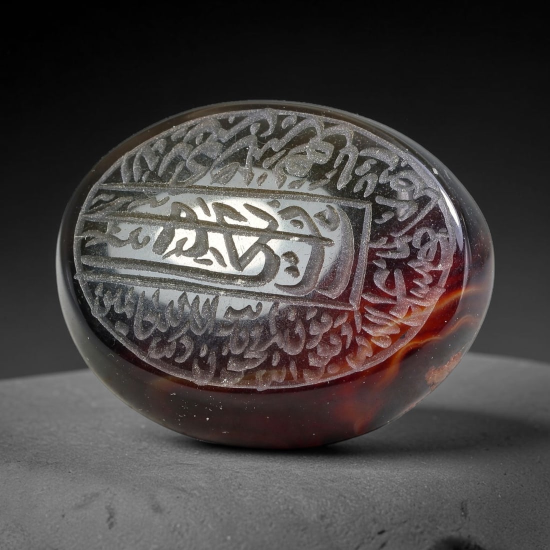 Ancient Medieval Mughal Islamic Carnelian Agate Calligraphic Script Talisman 1526-1857 CE, 26ES: Polished rich-toned carnelian agate cabochon, finely engraved with divided panels of Islamic calligraphic intaglio inscriptions. Deep crisp engraving features segmenting incised lines organizing the s