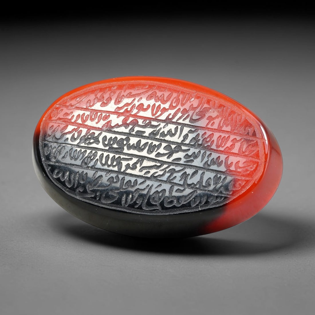 Ancient Medieval Mughal Islamic Carnelian Agate Calligraphic Script Talisman 1526-1857 CE, 22ES: Polished rich-toned carnelian agate cabochon, finely engraved with divided panels of Islamic calligraphic intaglio inscriptions. Deep crisp engraving features segmenting incised lines organizing the s