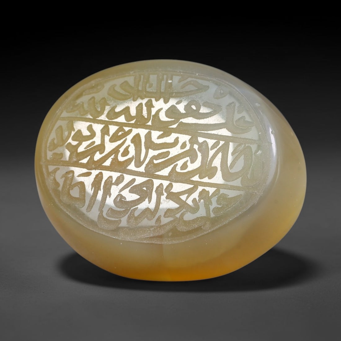 Ancient Medieval Mughal Islamic Carnelian Agate Calligraphic Script Talisman 1526-1857 CE, 54ES: Polished rich-toned carnelian agate cabochon, finely engraved with divided panels of Islamic calligraphic intaglio inscriptions. Deep crisp engraving features segmenting incised lines organizing the s