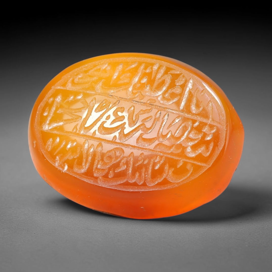Ancient Medieval Mughal Islamic Carnelian Agate Calligraphic Script Talisman 1526-1857 CE, 39ES: Polished rich-toned carnelian agate cabochon, finely engraved with divided panels of Islamic calligraphic intaglio inscriptions. Deep crisp engraving features segmenting incised lines organizing the s