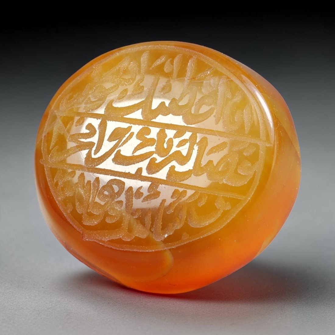 Ancient Medieval Mughal Islamic Carnelian Agate Calligraphic Script Talisman 1526-1857 CE, 35ES: Polished rich-toned carnelian agate cabochon, finely engraved with divided panels of Islamic calligraphic intaglio inscriptions. Deep crisp engraving features segmenting incised lines organizing the s