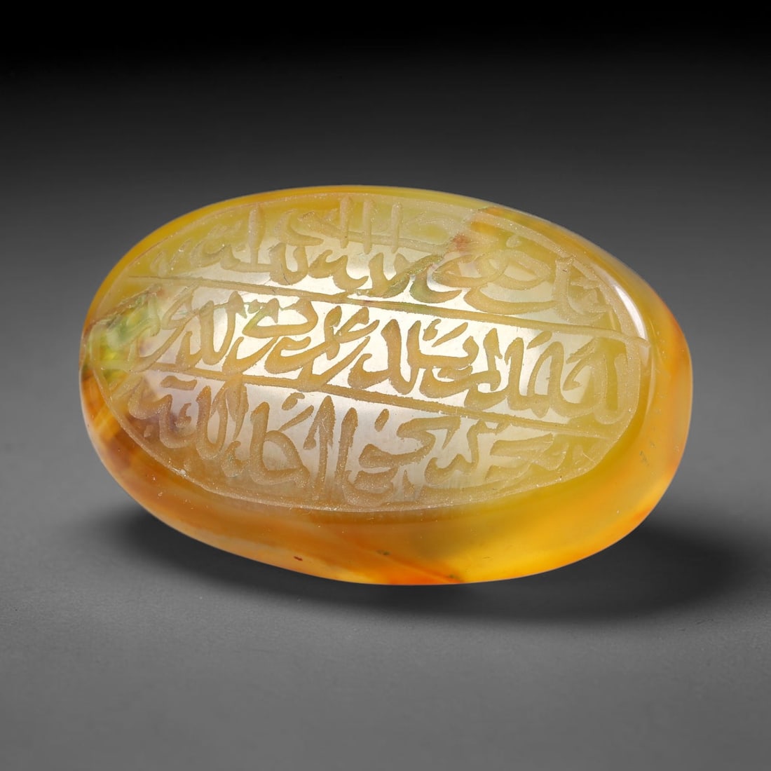 Ancient Medieval Mughal Islamic Carnelian Agate Calligraphic Script Talisman 1526-1857 CE, 34ES: Polished rich-toned carnelian agate cabochon, finely engraved with divided panels of Islamic calligraphic intaglio inscriptions. Deep crisp engraving features segmenting incised lines organizing the s