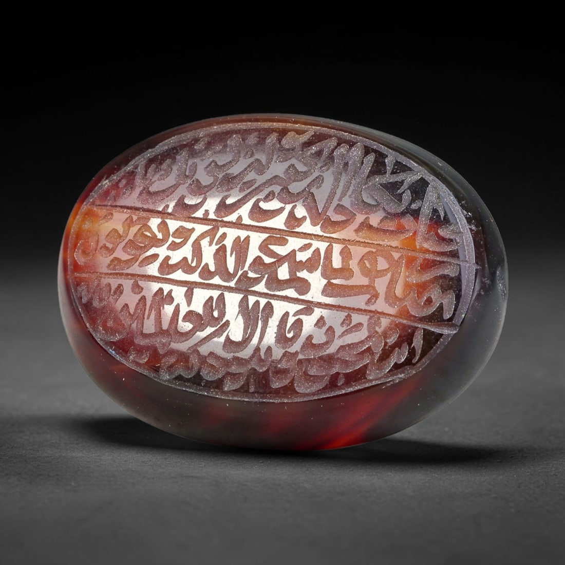 Ancient Medieval Mughal Islamic Carnelian Agate Calligraphic Script Talisman 1526-1857 CE, 43ES: Polished rich-toned carnelian agate cabochon, finely engraved with divided panels of Islamic calligraphic intaglio inscriptions. Deep crisp engraving features segmenting incised lines organizing the s