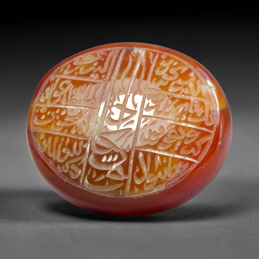 Ancient Medieval Mughal Islamic Carnelian Agate Calligraphic Script Talisman 1526-1857 CE, 23ES: Polished rich-toned carnelian agate cabochon, finely engraved with divided panels of Islamic calligraphic intaglio inscriptions. Deep crisp engraving features segmenting incised lines organizing the s