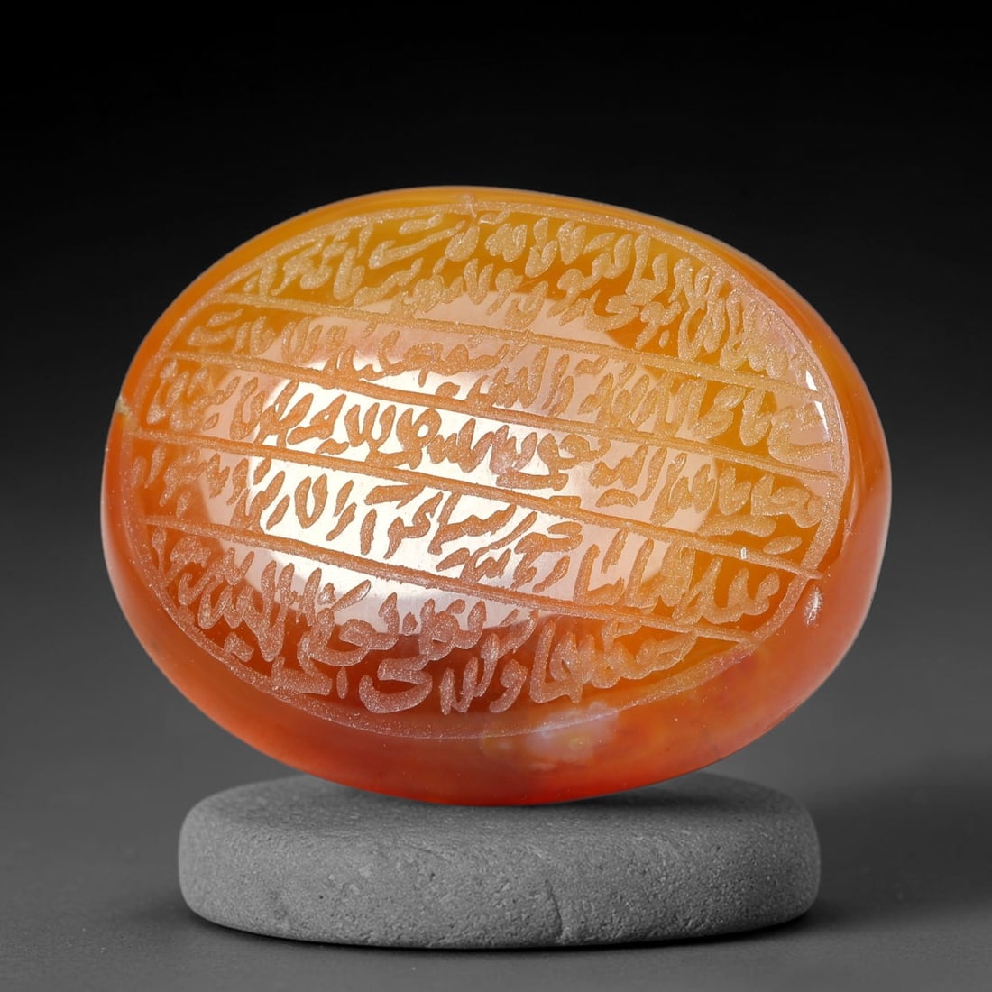 Ancient Medieval Mughal Islamic Carnelian Agate Calligraphic Script Talisman 1526-1857 CE, 40ES: Polished rich-toned carnelian agate cabochon, finely engraved with divided panels of Islamic calligraphic intaglio inscriptions. Deep crisp engraving features segmenting incised lines organizing the s