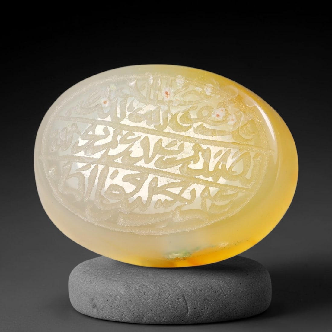 Ancient Medieval Mughal Islamic Carnelian Agate Calligraphic Script Talisman 1526-1857 CE, 60ES: Polished rich-toned carnelian agate cabochon, finely engraved with divided panels of Islamic calligraphic intaglio inscriptions. Deep crisp engraving features segmenting incised lines organizing the s