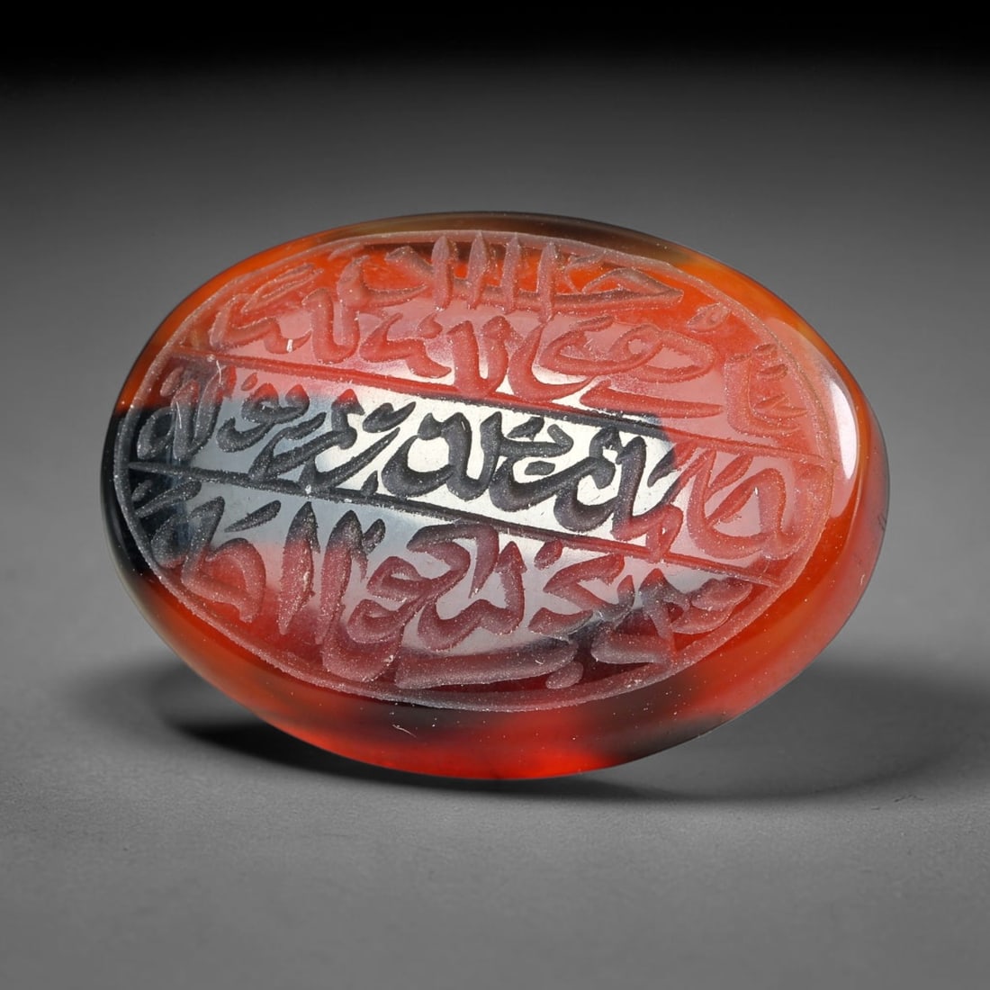 Ancient Medieval Mughal Islamic Carnelian Agate Calligraphic Script Talisman 1526-1857 CE, 51ES: Polished rich-toned carnelian agate cabochon, finely engraved with divided panels of Islamic calligraphic intaglio inscriptions. Deep crisp engraving features segmenting incised lines organizing the s