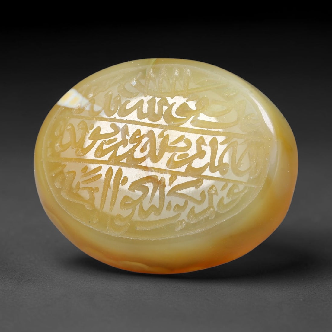 Ancient Medieval Mughal Islamic Carnelian Agate Calligraphic Script Talisman 1526-1857 CE, 53ES: Polished rich-toned carnelian agate cabochon, finely engraved with divided panels of Islamic calligraphic intaglio inscriptions. Deep crisp engraving features segmenting incised lines organizing the s