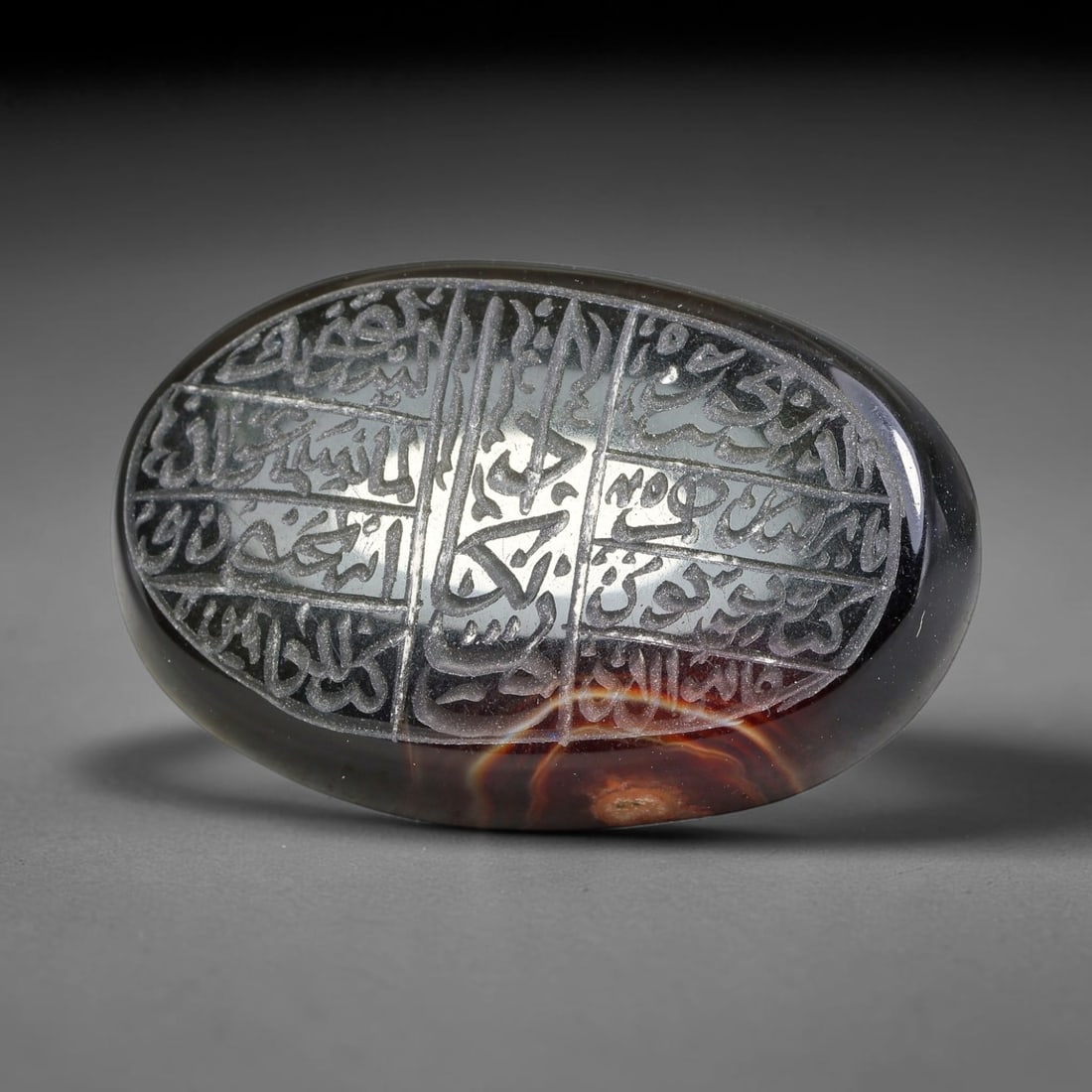Ancient Medieval Mughal Islamic Carnelian Agate Calligraphic Script Talisman 1526-1857 CE, 42ES: Polished rich-toned carnelian agate cabochon, finely engraved with divided panels of Islamic calligraphic intaglio inscriptions. Deep crisp engraving features segmenting incised lines organizing the s