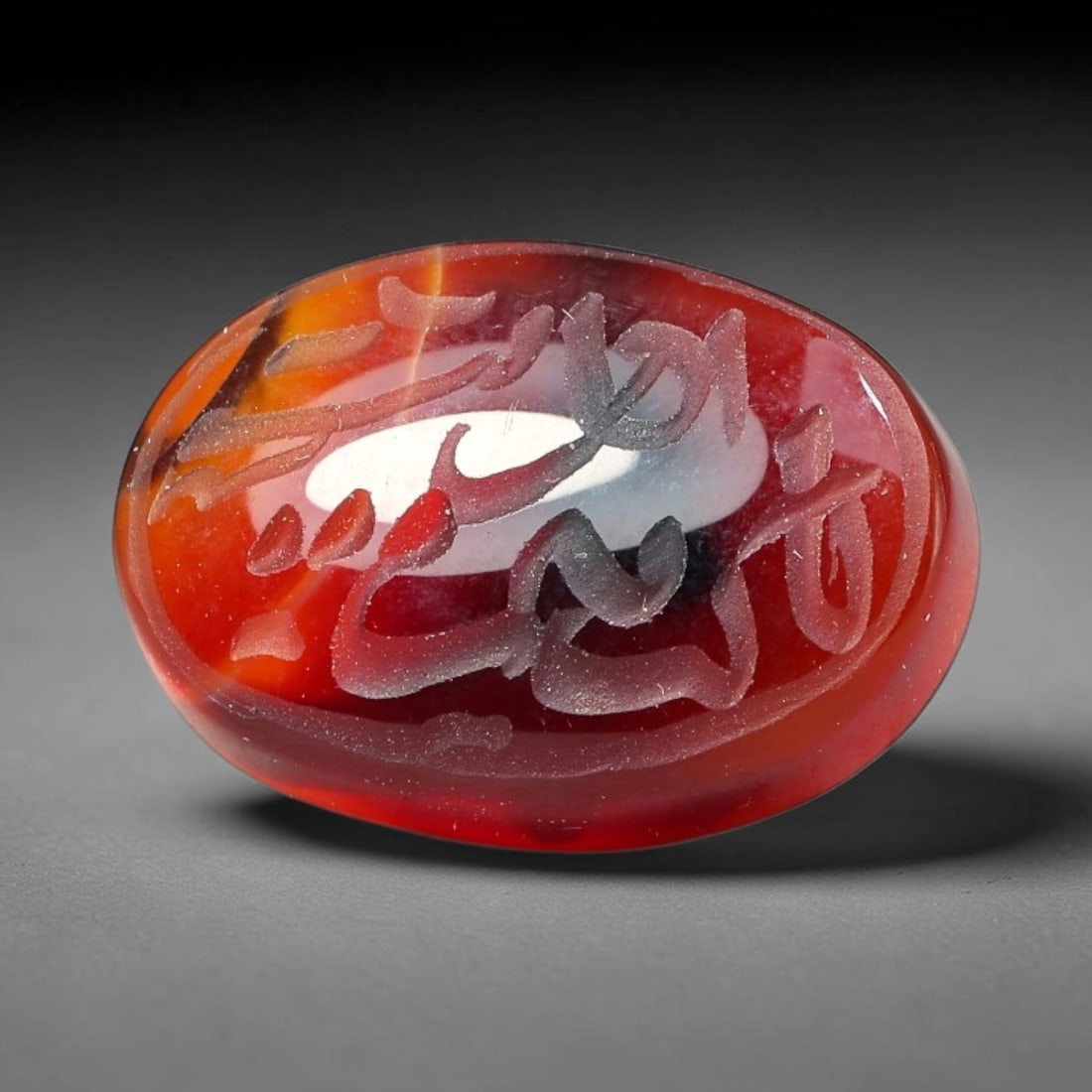 Ancient Medieval Mughal Islamic Carnelian Agate Calligraphic Script Talisman 1526-1857 CE, 56ES: Polished rich-toned carnelian agate cabochon, finely engraved with divided panels of Islamic calligraphic intaglio inscriptions. Deep crisp engraving features segmenting incised lines organizing the s
