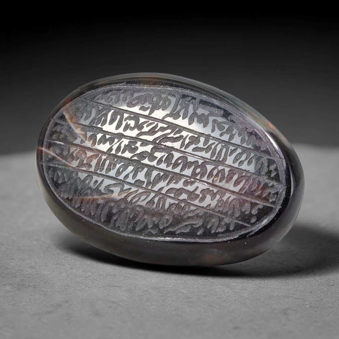 Ancient Medieval Mughal Islamic Carnelian Agate Calligraphic Script Talisman 1526-1857 CE, 100ES: Polished rich-toned carnelian agate cabochon, finely engraved with divided panels of Islamic calligraphic intaglio inscriptions. Deep crisp engraving features segmenting incised lines organizing the s