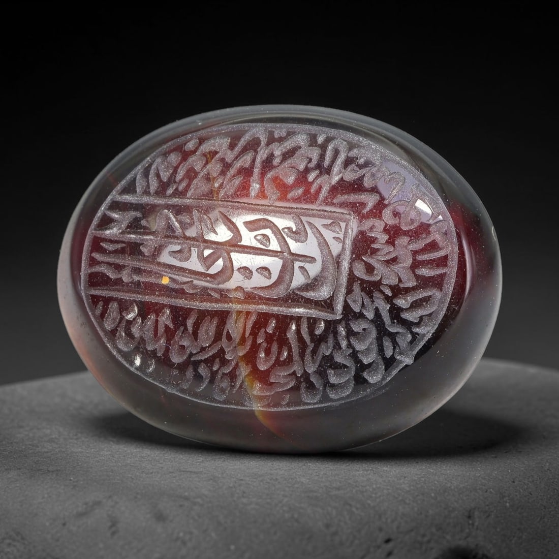 Ancient Medieval Mughal Islamic Carnelian Agate Calligraphic Script Talisman 1526-1857 CE, 78ES: Polished rich-toned carnelian agate cabochon, finely engraved with divided panels of Islamic calligraphic intaglio inscriptions. Deep crisp engraving features segmenting incised lines organizing the s