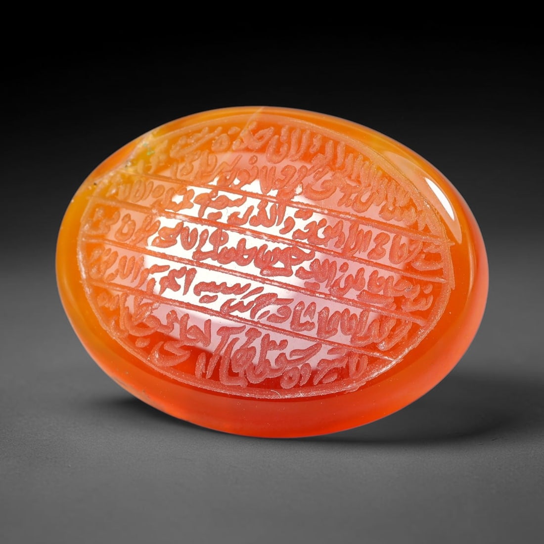 Ancient Medieval Mughal Islamic Carnelian Agate Calligraphic Script Talisman 1526-1857 CE, 33ET: Polished rich-toned carnelian agate cabochon, finely engraved with divided panels of Islamic calligraphic intaglio inscriptions. Deep crisp engraving features segmenting incised lines organizing the s