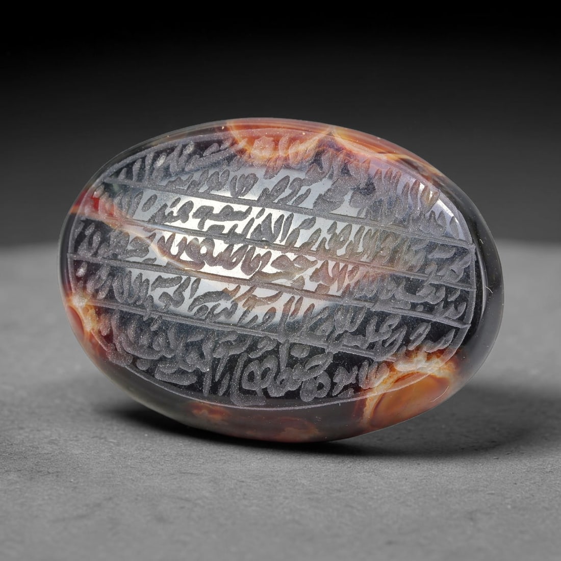 Ancient Medieval Mughal Islamic Carnelian Agate Calligraphic Script Talisman 1526-1857 CE, 95ES: Polished rich-toned carnelian agate cabochon, finely engraved with divided panels of Islamic calligraphic intaglio inscriptions. Deep crisp engraving features segmenting incised lines organizing the s