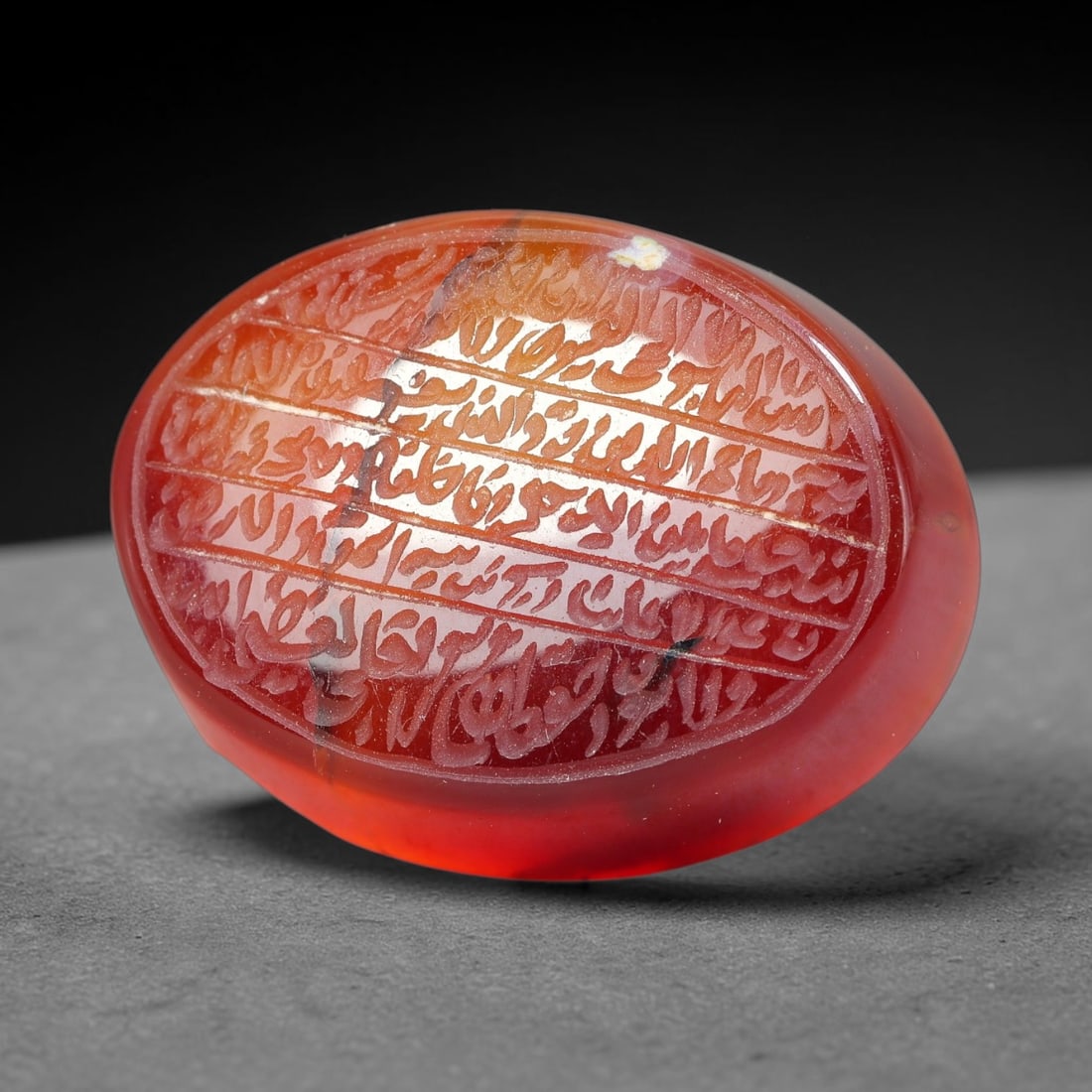 Ancient Medieval Mughal Islamic Carnelian Agate Calligraphic Script Talisman 1526-1857 CE, 11ET: Polished rich-toned carnelian agate cabochon, finely engraved with divided panels of Islamic calligraphic intaglio inscriptions. Deep crisp engraving features segmenting incised lines organizing the s