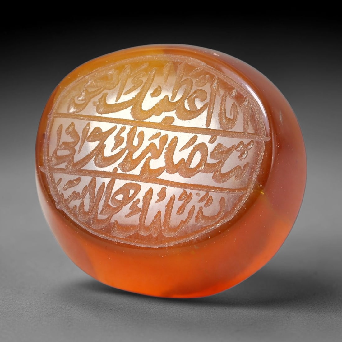 Ancient Medieval Mughal Islamic Carnelian Agate Calligraphic Script Talisman 1526-1857 CE, 16ET: Polished rich-toned carnelian agate cabochon, finely engraved with divided panels of Islamic calligraphic intaglio inscriptions. Deep crisp engraving features segmenting incised lines organizing the s