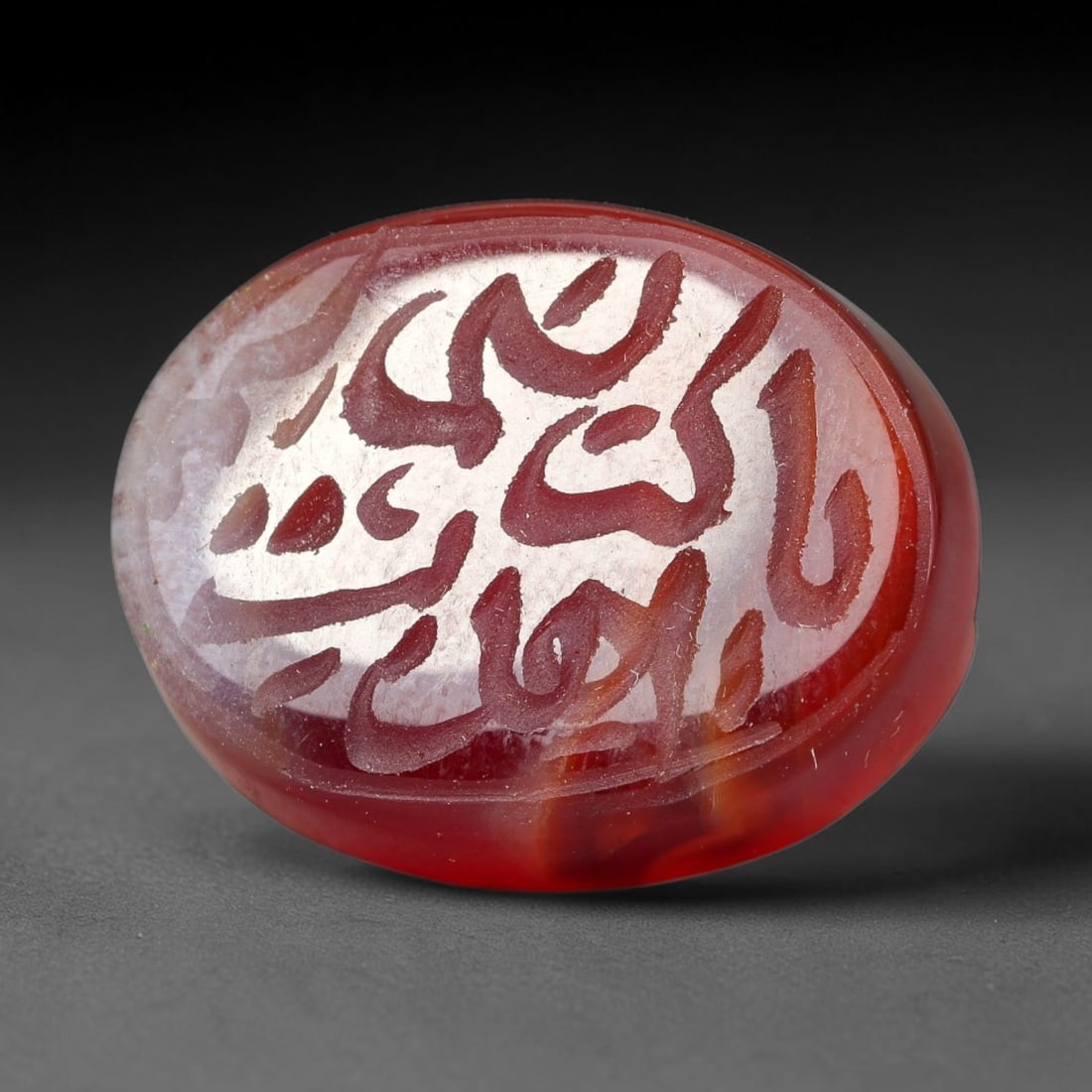 Ancient Medieval Mughal Islamic Carnelian Agate Calligraphic Script Talisman 1526-1857 CE, 41ET: Polished rich-toned carnelian agate cabochon, finely engraved with divided panels of Islamic calligraphic intaglio inscriptions. Deep crisp engraving features segmenting incised lines organizing the s
