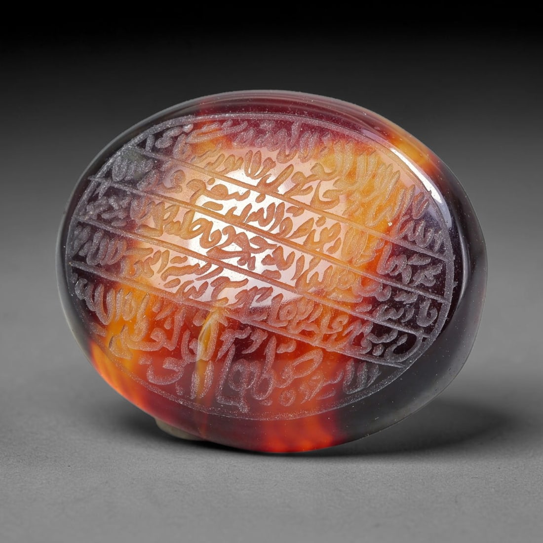 Ancient Medieval Mughal Islamic Carnelian Agate Calligraphic Script Talisman 1526-1857 CE, 83ES: Polished rich-toned carnelian agate cabochon, finely engraved with divided panels of Islamic calligraphic intaglio inscriptions. Deep crisp engraving features segmenting incised lines organizing the s