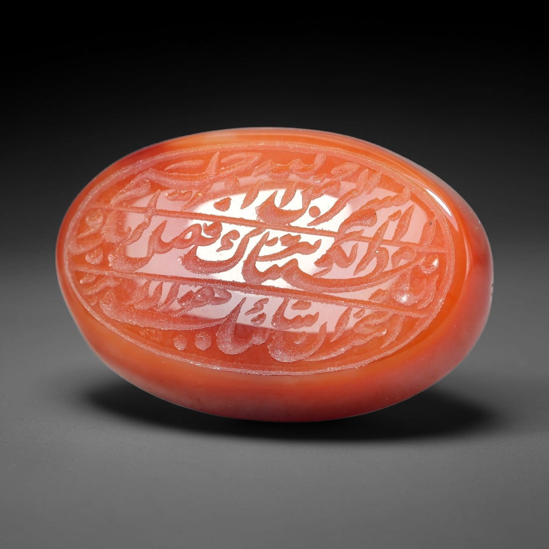 Ancient Medieval Mughal Islamic Carnelian Agate Calligraphic Script Talisman 1526-1857 CE, 15ET: Polished rich-toned carnelian agate cabochon, finely engraved with divided panels of Islamic calligraphic intaglio inscriptions. Deep crisp engraving features segmenting incised lines organizing the s