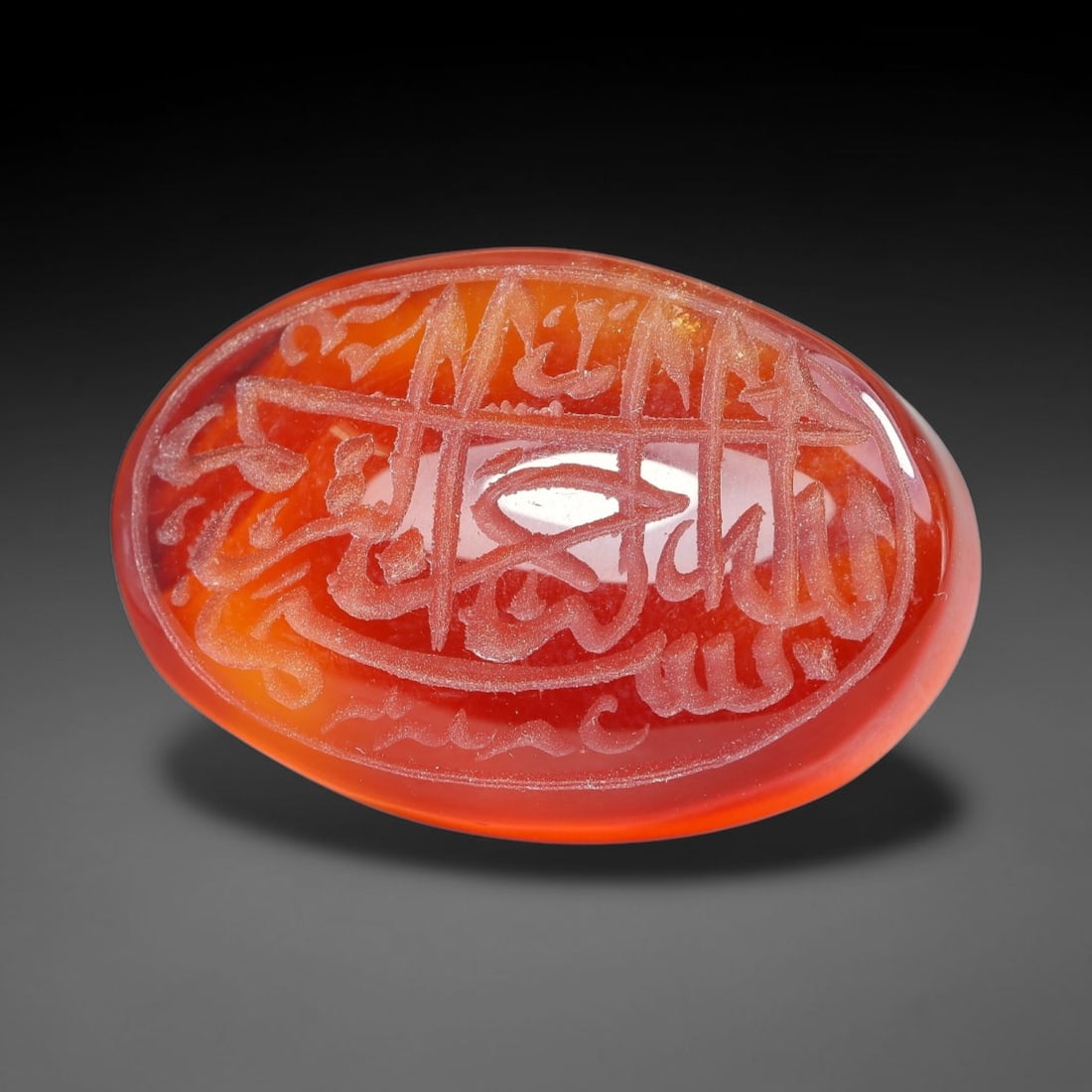 Ancient Medieval Mughal Islamic Carnelian Agate Calligraphic Script Talisman 1526-1857 CE, 99ES: Polished rich-toned carnelian agate cabochon, finely engraved with divided panels of Islamic calligraphic intaglio inscriptions. Deep crisp engraving features segmenting incised lines organizing the s