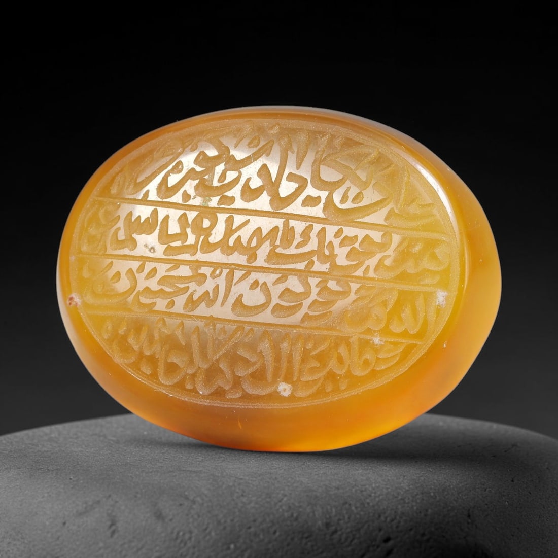 Ancient Medieval Mughal Islamic Carnelian Agate Calligraphic Script Talisman 1526-1857 CE, 79ES: Polished rich-toned carnelian agate cabochon, finely engraved with divided panels of Islamic calligraphic intaglio inscriptions. Deep crisp engraving features segmenting incised lines organizing the s