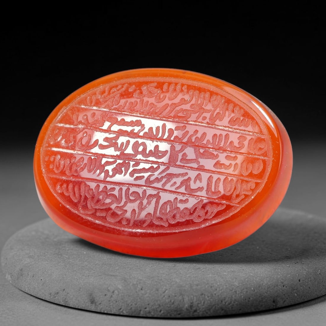 Ancient Medieval Mughal Islamic Carnelian Agate Calligraphic Script Talisman 1526-1857 CE, 37ET: Polished rich-toned carnelian agate cabochon, finely engraved with divided panels of Islamic calligraphic intaglio inscriptions. Deep crisp engraving features segmenting incised lines organizing the s