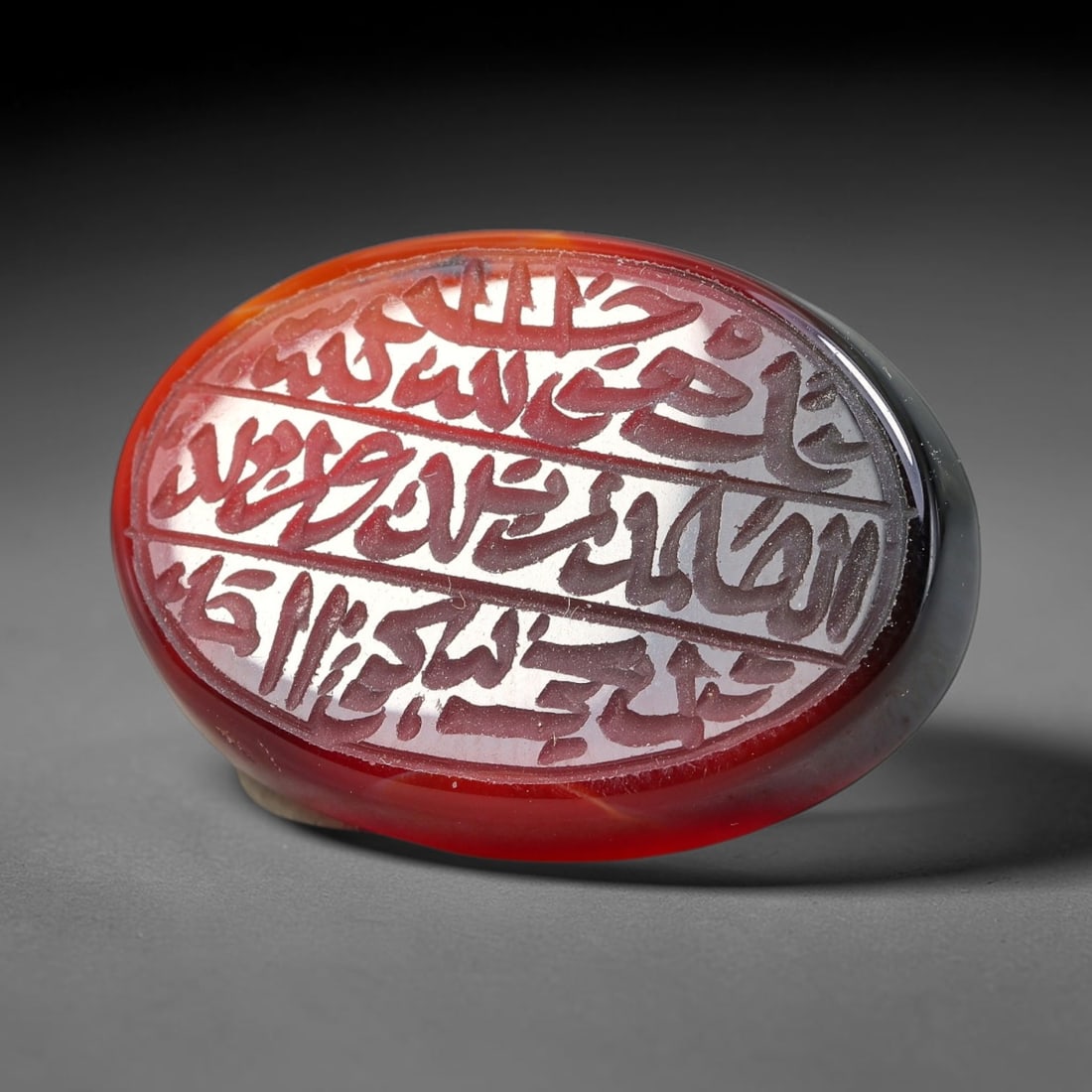 Ancient Medieval Mughal Islamic Carnelian Agate Calligraphic Script Talisman 1526-1857 CE, 32ET: Polished rich-toned carnelian agate cabochon, finely engraved with divided panels of Islamic calligraphic intaglio inscriptions. Deep crisp engraving features segmenting incised lines organizing the s