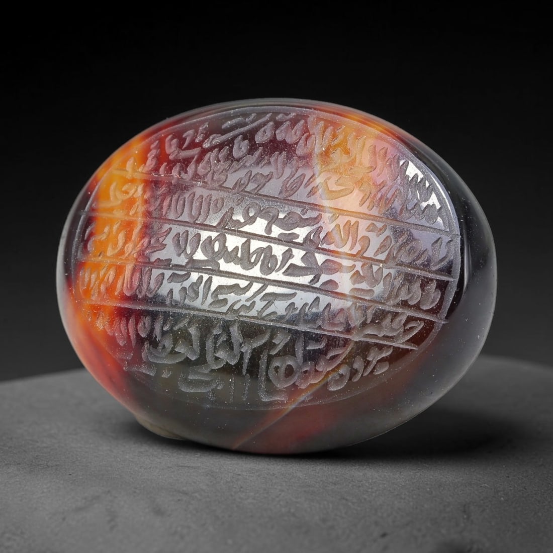 Ancient Medieval Mughal Islamic Carnelian Agate Calligraphic Script Talisman 1526-1857 CE, 93ES: Polished rich-toned carnelian agate cabochon, finely engraved with divided panels of Islamic calligraphic intaglio inscriptions. Deep crisp engraving features segmenting incised lines organizing the s