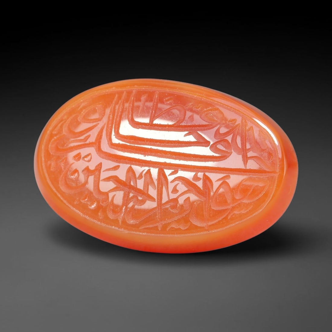 Ancient Medieval Mughal Islamic Carnelian Agate Calligraphic Script Talisman 1526-1857 CE, 96ES: Polished rich-toned carnelian agate cabochon, finely engraved with divided panels of Islamic calligraphic intaglio inscriptions. Deep crisp engraving features segmenting incised lines organizing the s