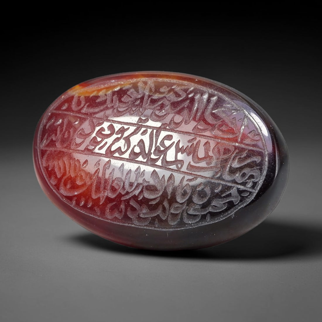 Ancient Medieval Mughal Islamic Carnelian Agate Calligraphic Script Talisman 1526-1857 CE, 5ET: Polished rich-toned carnelian agate cabochon, finely engraved with divided panels of Islamic calligraphic intaglio inscriptions. Deep crisp engraving features segmenting incised lines organizing the s