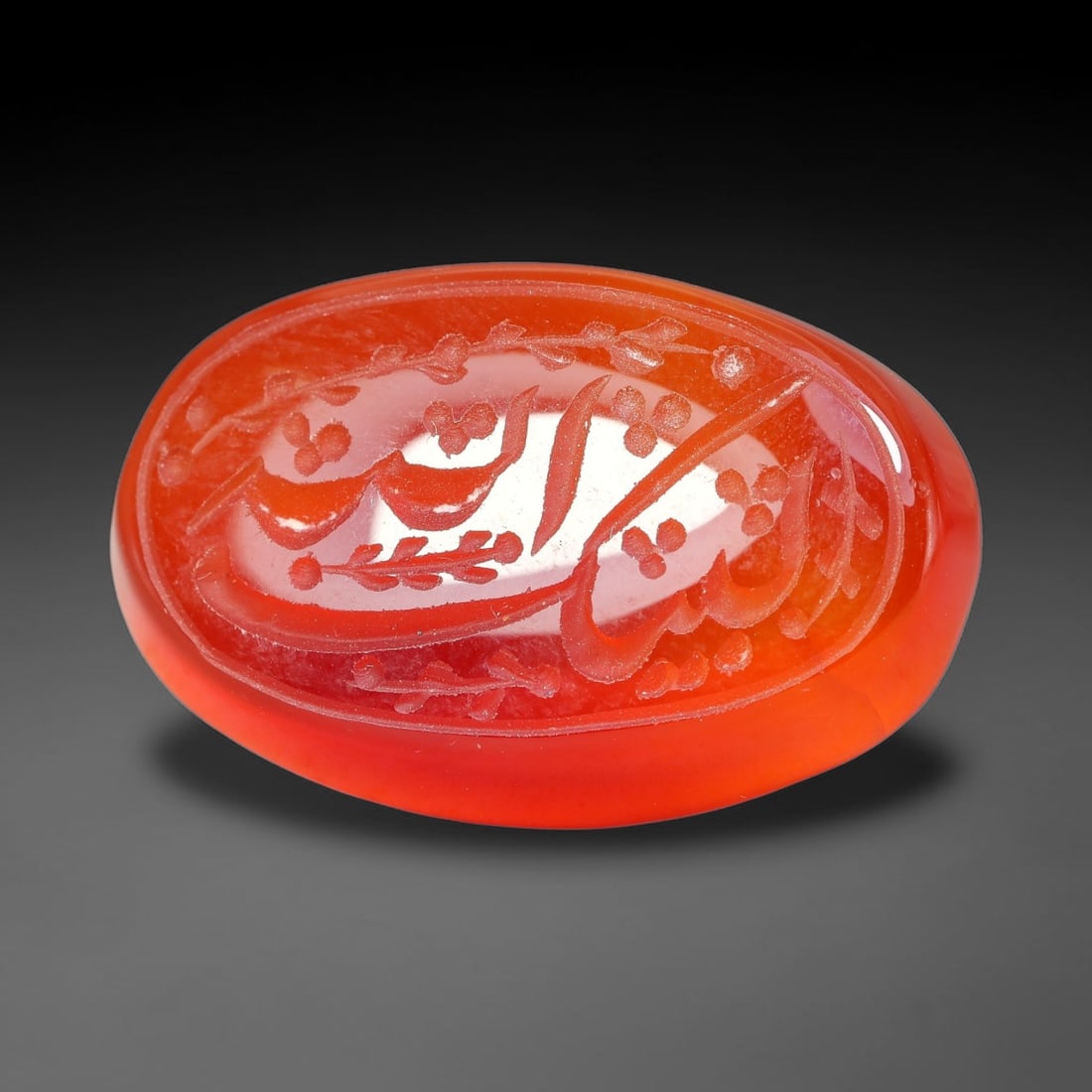 Ancient Medieval Mughal Islamic Carnelian Agate Calligraphic Script Talisman 1526-1857 CE, 19ET: Polished rich-toned carnelian agate cabochon, finely engraved with divided panels of Islamic calligraphic intaglio inscriptions. Deep crisp engraving features segmenting incised lines organizing the s