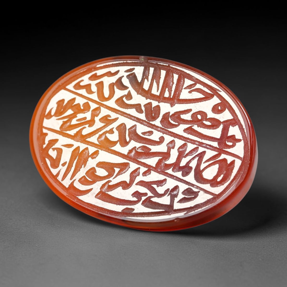 Ancient Medieval Mughal Islamic Carnelian Agate Calligraphic Script Talisman 1526-1857 CE, 31ET: Polished rich-toned carnelian agate cabochon, finely engraved with divided panels of Islamic calligraphic intaglio inscriptions. Deep crisp engraving features segmenting incised lines organizing the s