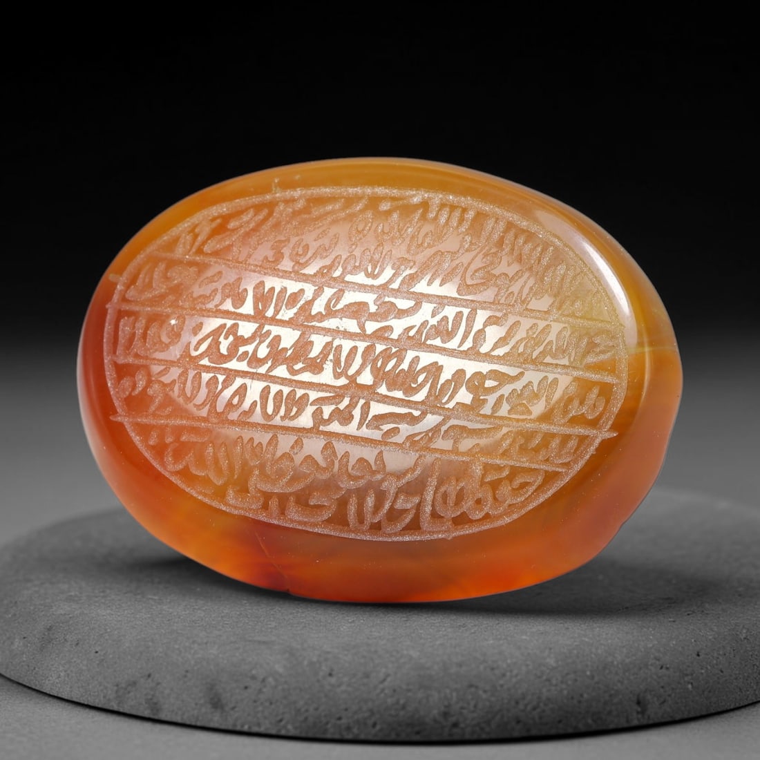 Ancient Medieval Mughal Islamic Carnelian Agate Calligraphic Script Talisman 1526-1857 CE, 90ES: Polished rich-toned carnelian agate cabochon, finely engraved with divided panels of Islamic calligraphic intaglio inscriptions. Deep crisp engraving features segmenting incised lines organizing the s