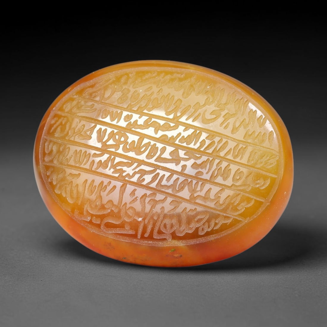 Ancient Medieval Mughal Islamic Carnelian Agate Calligraphic Script Talisman 1526-1857 CE, 91ES: Polished rich-toned carnelian agate cabochon, finely engraved with divided panels of Islamic calligraphic intaglio inscriptions. Deep crisp engraving features segmenting incised lines organizing the s
